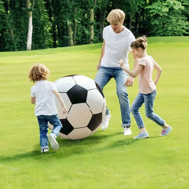Family playing with the giant football on the lawn
